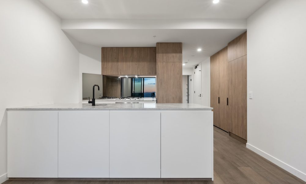 a large kitchen with a white counter top and wooden cabinets