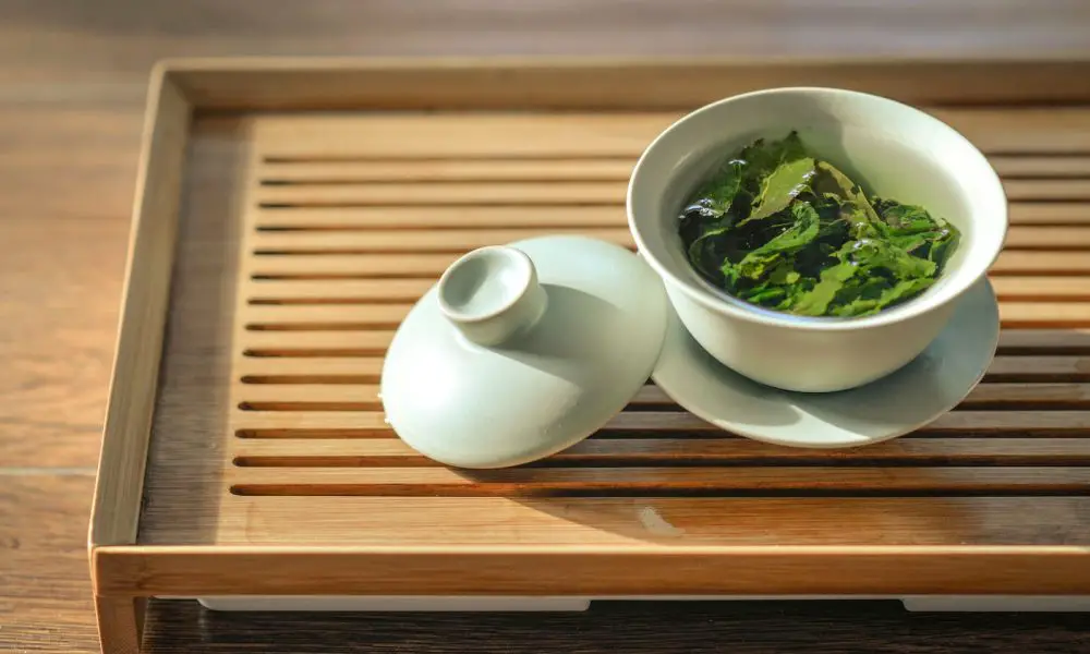 green tea leaves in white ceramic bowl with open lid