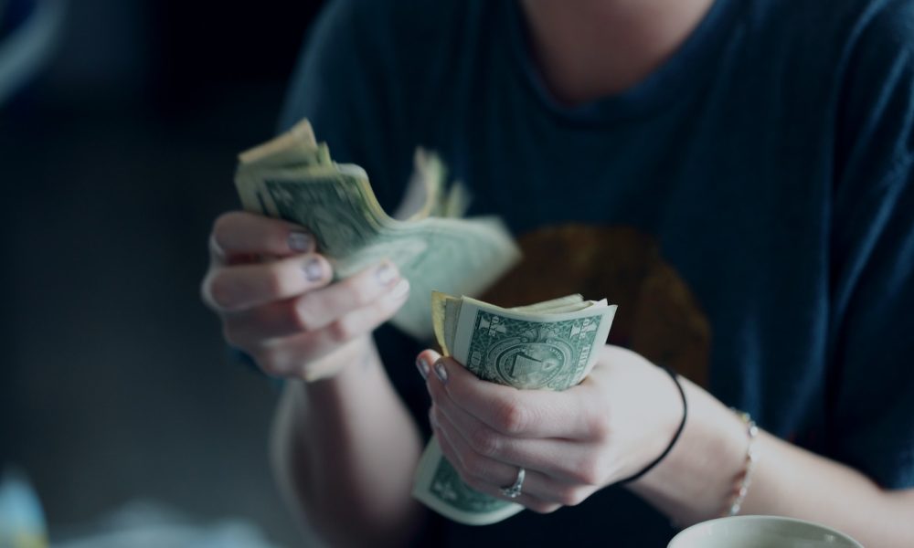 focus photography of person counting dollar banknotes