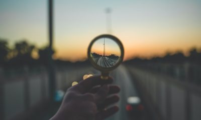 person holding magnifying glass during sunset
