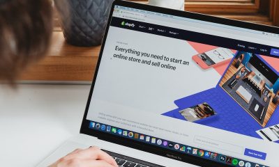 person using macbook pro on white table