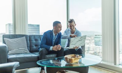 two men in suit sitting on sofa