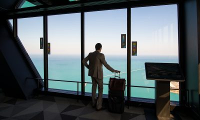 man in white shirt standing near glass window