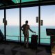 man in white shirt standing near glass window