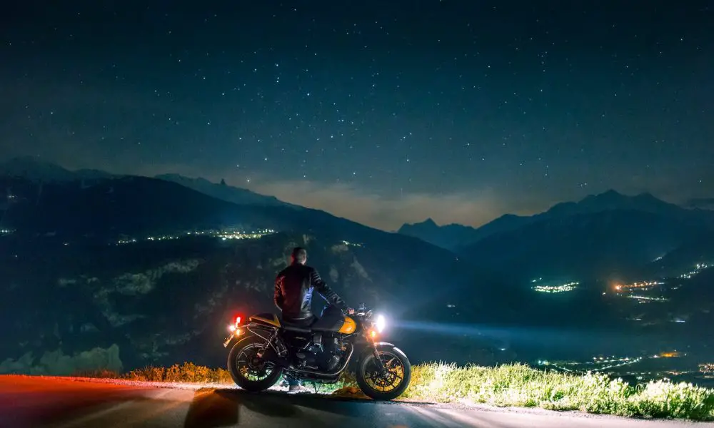 man siting on motorcycle at night