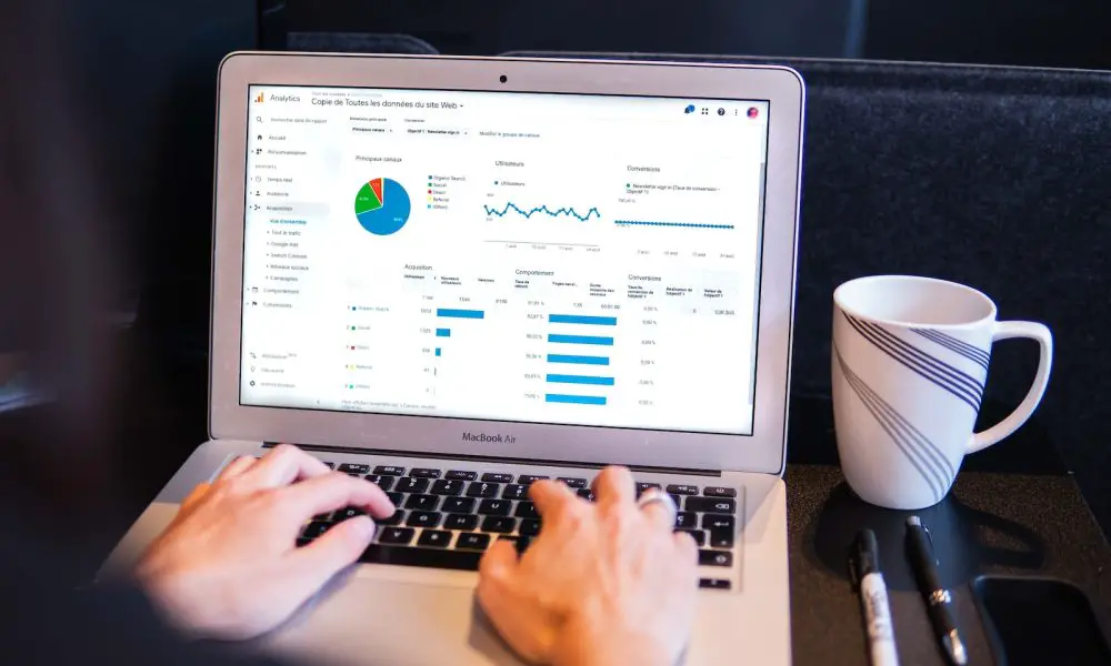 person using macbook pro on black table