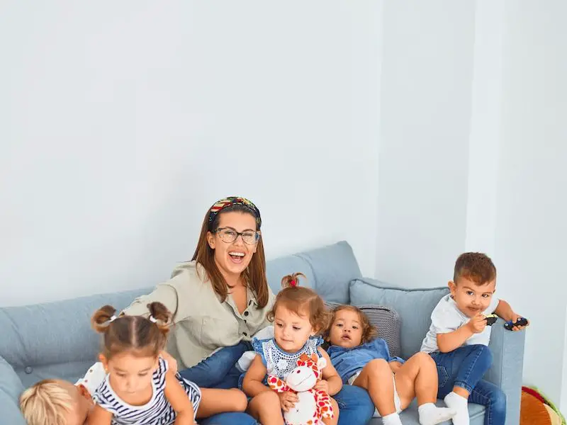 3 women sitting on gray couch