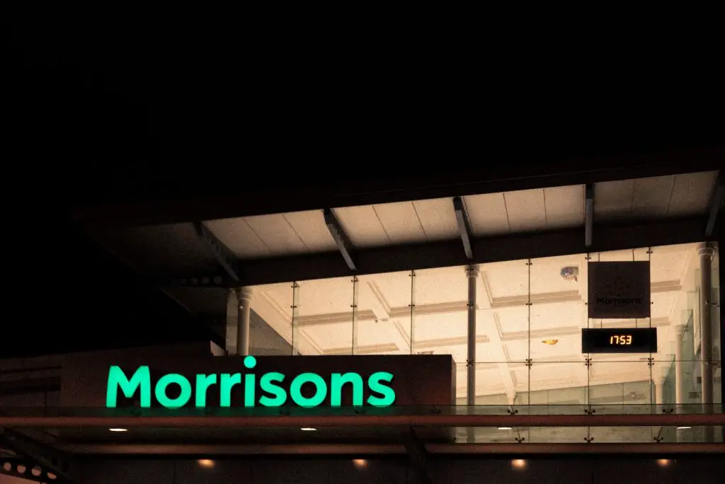 a neon sign that reads morrisons in front of a building