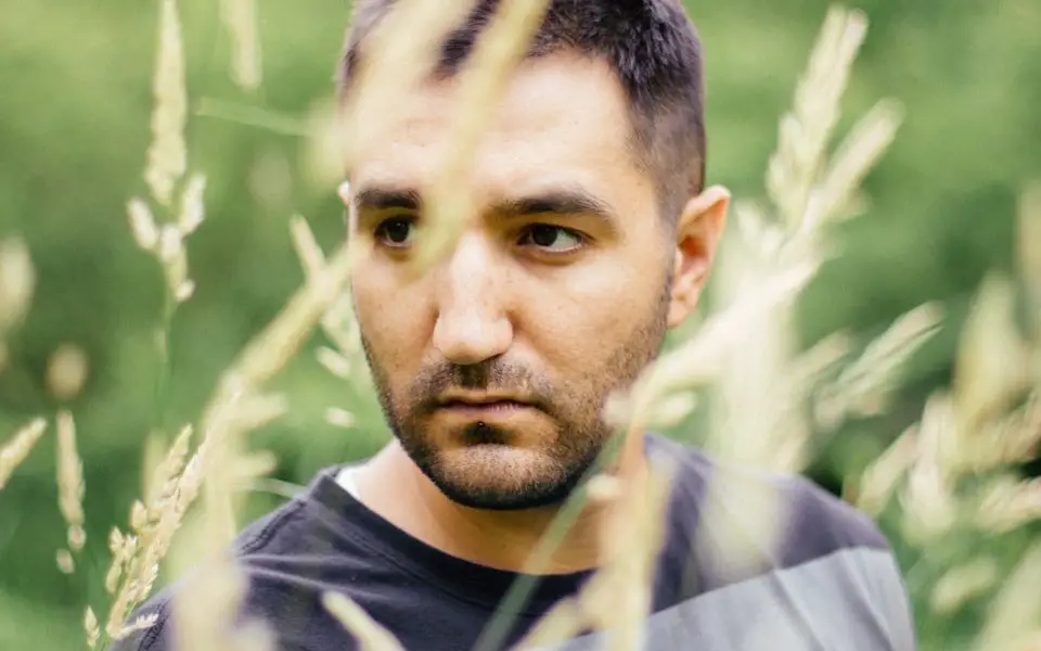 a man standing in a field of tall grass