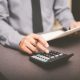 businessman uses calculator for profit loss review 462557409 bigstock scaled